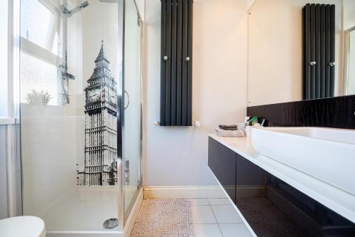 baño con ducha y una foto de la torre del reloj en Le Cwtch - Beautiful 1 bed boutique apartment en Cardiff