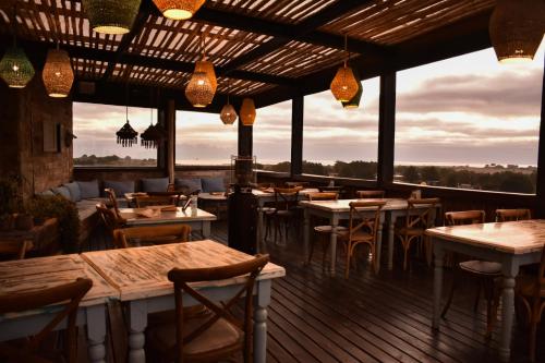 a restaurant with tables and chairs on a deck at Cuarzo Lodge in Pichilemu