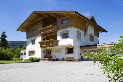 a large white building with a wooden roof at Apartmenthaus Brigitte in Leutasch