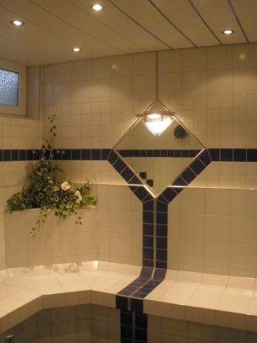 a bathroom with a tub with a reflection in it at Apartmenthaus Brigitte in Leutasch