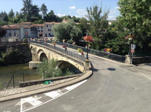 un camino vacío con un puente sobre un río en La Maison de la Riviere B&B, en Espéraza
