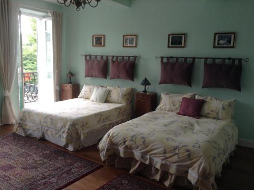 two beds sitting next to each other in a bedroom at La Maison de la Riviere B&B in Espéraza