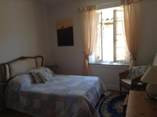 a bedroom with a bed and a window at La Maison de la Riviere B&B in Espéraza