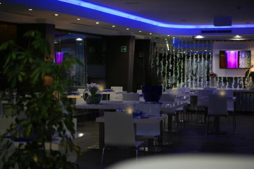 a dining room with white tables and white chairs at A Point Porto Ercole Resort & Spa in Porto Ercole