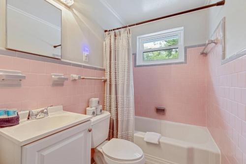 a pink bathroom with a toilet and a sink at 208 W Ashley - Central Location - 2 Mins to the Beach in Folly Beach