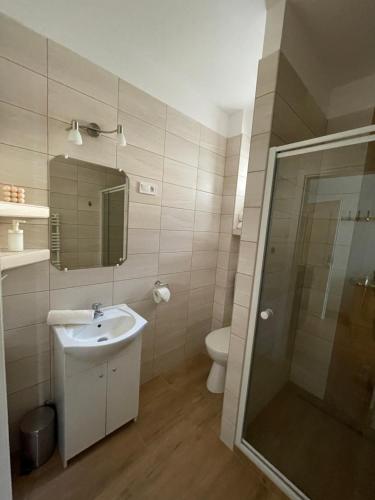 y baño con aseo, lavabo y ducha. en Gólyafészek Vendégház, en Egerszalók