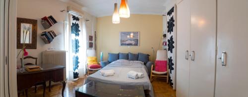 um quarto com uma cama e um sofá azul em My Home at Koukaki em Atenas
