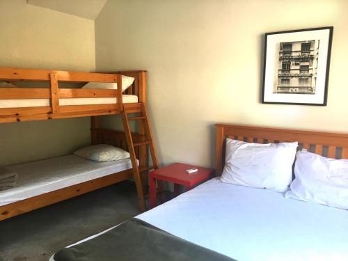 1 dormitorio con 2 literas, 1 cama y un banco en Vila Praiana, en Ubatuba