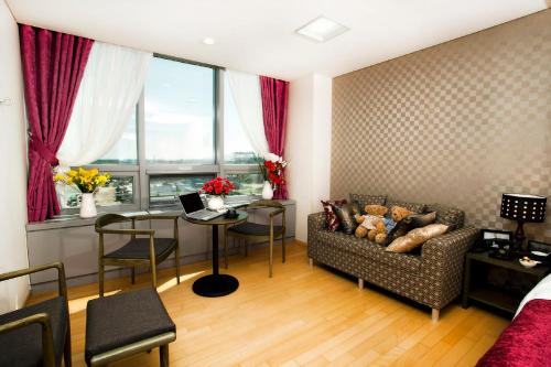 a living room with a couch and a table at Hotel Hu Incheon Airport in Incheon