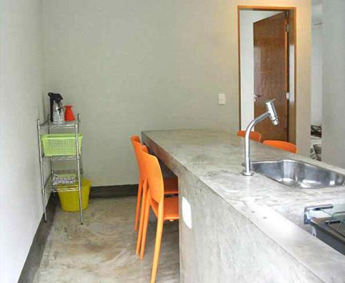 a kitchen with a sink and orange chairs at Vila Praiana in Ubatuba