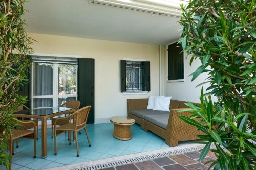 une terrasse avec un canapé, une table et des chaises dans l'établissement Villa Carlotta Jesolo Lido, à Lido di Jesolo