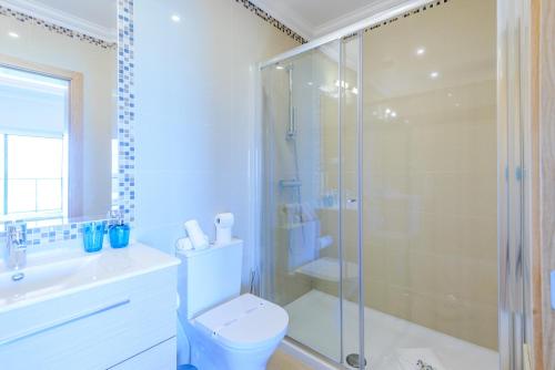 une salle de bain avec toilettes et douche en verre dans l'établissement Boavista Golf and Spa Resort - Bayview, à Quatro Estradas