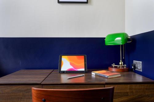 a desk with a laptop and a lamp on it at D8 House in London