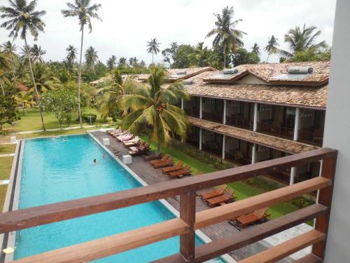 a view of the pool from the balcony of a hotel at Paradise Beach Club in Mirissa