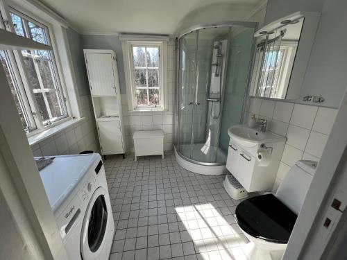 a bathroom with a shower and a washing machine at Tutviksvägen 35 in Vendelsö