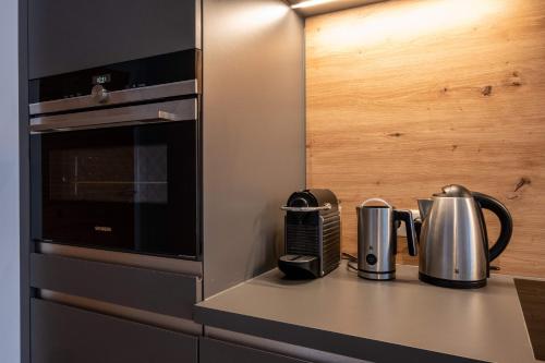 a kitchen counter with two silver appliances on it at Das Taja Paznaun Penthouse Apartments in See