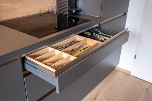 a kitchen with an open drawer with tools in it at Das Taja Paznaun Penthouse Apartments in See