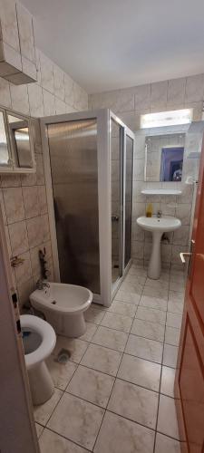 a bathroom with two toilets and a shower and a sink at CENTRAL APARTAMENT La malul marii 3 camere & Living in Mangalia
