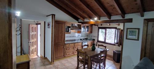 a kitchen with a table and a dining room at Apartamento El Nial de Potes in Potes