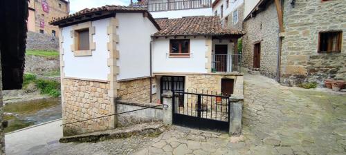 a white building with a gate in an alley at Apartamento El Nial de Potes in Potes