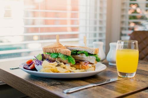 a sandwich and chips and a glass of orange juice at The Maynard in Scarborough
