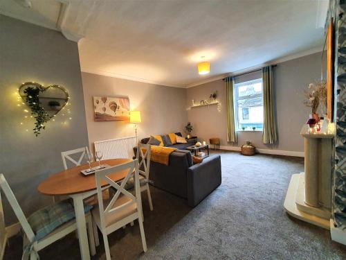 a living room with a couch and a table at Brodie's Hideaway: Stylish two-bed Amble apartment in Amble