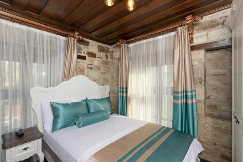 a bedroom with a white bed with blue pillows at Marina Foça Hotel in Foca