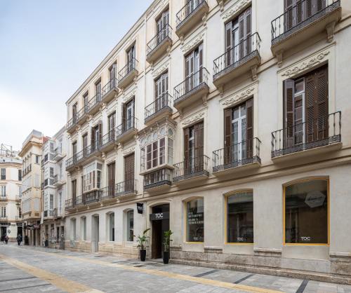 a large white building with balconies on a street at TOC Hostel Malaga in Málaga