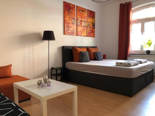 ein kleines Schlafzimmer mit einem Bett und einem Tisch in der Unterkunft City Quartier Jena in Jena