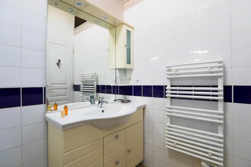 een witte badkamer met een wastafel en een spiegel bij Maison de village Casserone pour 4 personnes in Ars-en-Ré