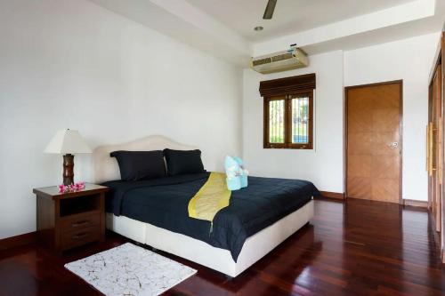 a bedroom with a bed with a night stand and a window at Villa E in Taling Ngam Beach