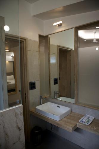 a bathroom with a sink and a large mirror at Pai Resort in Belgaum