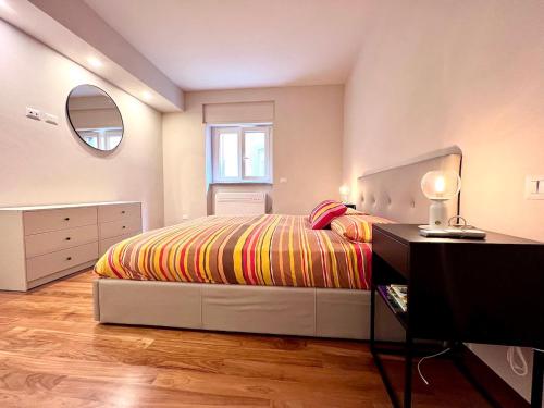 Schlafzimmer mit einem Bett, einer Kommode und einem Spiegel in der Unterkunft Casa San Giusto in Lucca