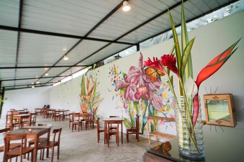 a restaurant with tables and chairs and a flower mural at Country Club Eco Casajardin in Moyobamba
