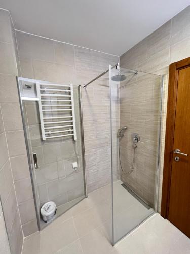 a shower with a glass door in a bathroom at Varja 3 Apartment in Pržno