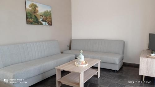 a living room with two couches and a coffee table at Sunshine Apartments in Kato Daratso