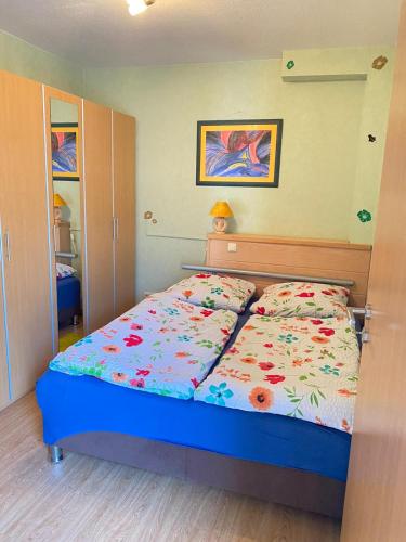 een slaapkamer met een bed met een bloemdekbed bij Ferienwohnung Pupavac in Bad Frankenhausen