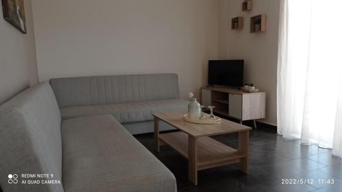 a living room with a couch and a table at Sunshine Apartments in Kato Daratso