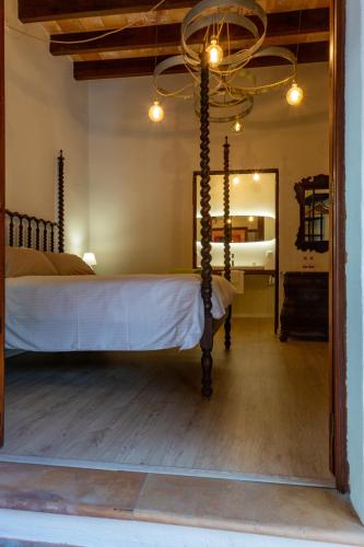 a bedroom with a bed with a chandelier and a mirror at Sa Barcella TI 64 in Sineu