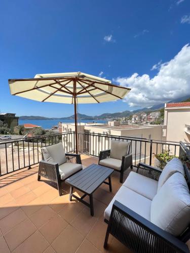 a patio with a couch and a table and an umbrella at Varja 3 Apartment in Pržno