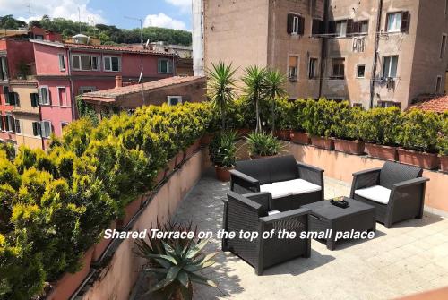a small patio with chairs and tables on a roof at DormiRoma - Cedro 21 Apartments in Rome