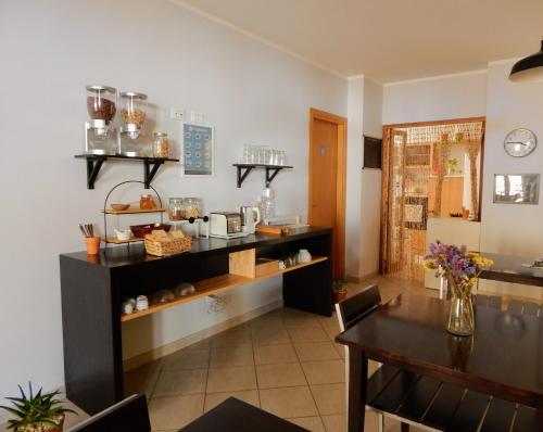 ein Esszimmer mit einem Tisch und einer Theke mit Tassen in der Unterkunft Bed & Breakfast Tiziana in Castellammare del Golfo