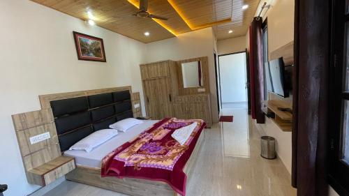 a bedroom with a bed and a flat screen tv at Hotel Forest View Dalhousie, Banikhet in Dalhousie