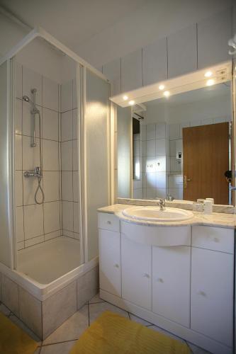 a bathroom with a sink and a shower and a mirror at House Peri in Trogir