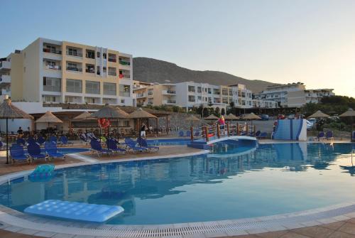 Una gran piscina con sillas y edificios azules. en Mediterraneo Hotel, en Hersonissos