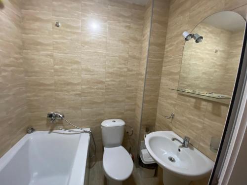 a bathroom with a white toilet and a sink at Complex Magic of the Rhodopes in Bachkovo