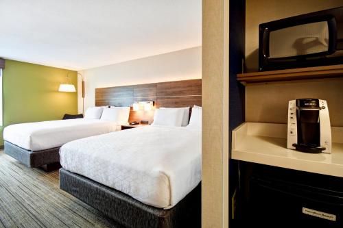 a hotel room with two beds and a tv at Holiday Inn Express Newport North - Middletown by IHG in Middletown