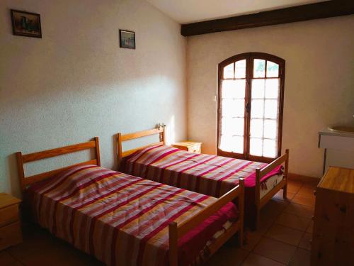 deux lits dans une chambre avec une fenêtre dans l'établissement 6COMA6 Appartement avec terrasse vue mer, à Collioure