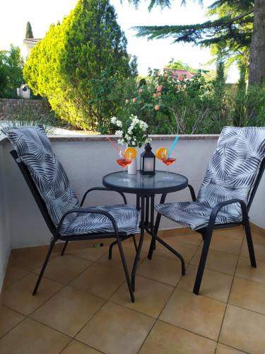 two chairs and a table on a patio at Katy in Krk