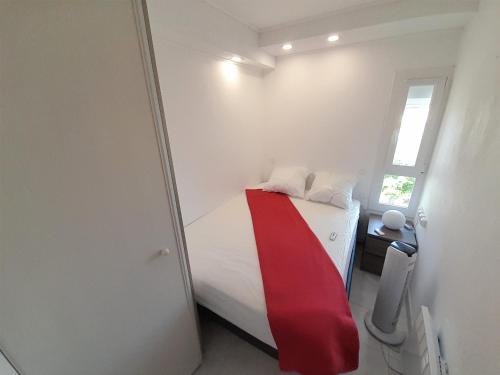 une chambre avec un lit avec une couverture rouge dessus dans l'établissement Appartement Village Naturiste Psikedelik, au Cap d'Agde